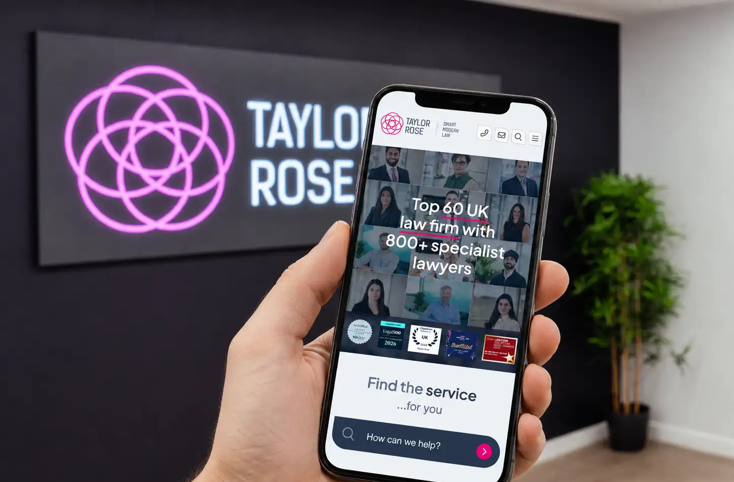 Taylor Rose website on a phone in front of the illuminated office sign